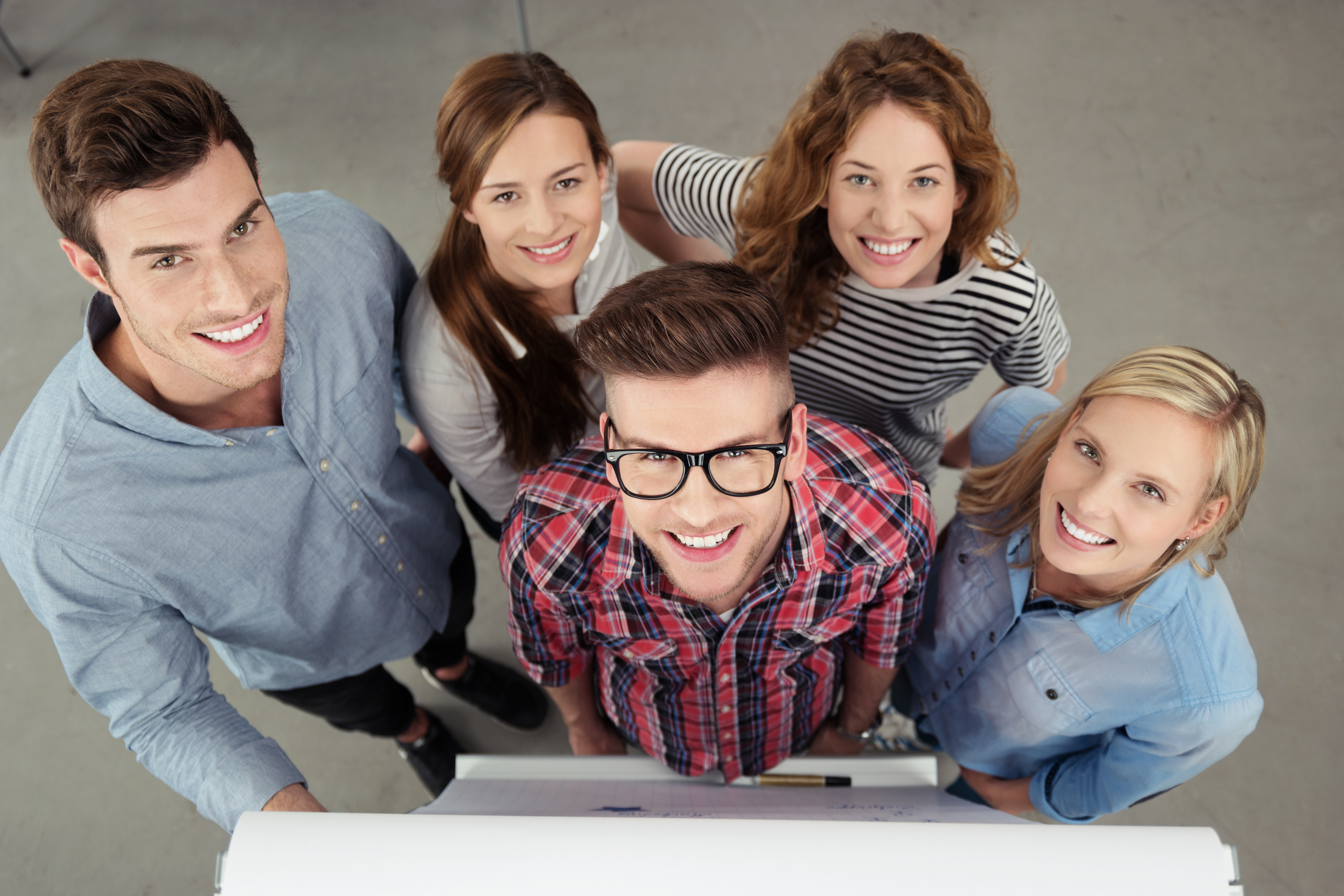 Un groupe de jeunes souriants devant un storyboard
